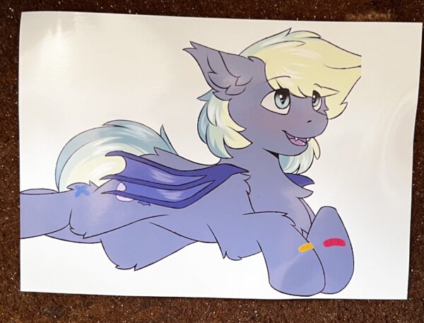Photo of print with Murphy laying down with an open mouth smile and looking up. Art by Snowstormbat